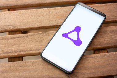 Amazon Luna logosu Android akıllı telefon ekranında arka planda MacBook Pro ile birlikte, bulut oyunları ve platformlar arası teknolojiyi temsil ediyor.