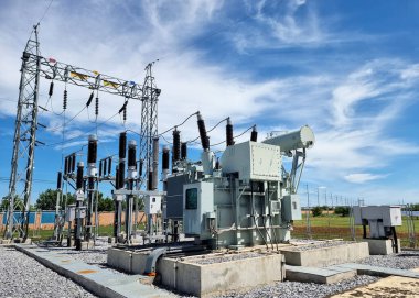 115 kV kalkış kulesi ve Transformer besleme cihazı bulutlar ve mavi gökyüzü arka planındaki bir alt istasyon santralinde..