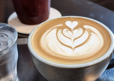 Bir fincan sıcak latte, sanat eseri, lale kahvesi ve içme suyu..