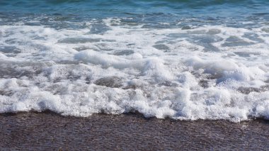 Köpüklü mavi su ile deniz kıyısında deniz manzarası