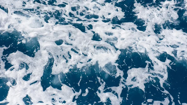 Ανήσυχος, πιτσίλισμα αφρώδες γαλάζια θάλασσα νερό από ψηλά — Φωτογραφία Αρχείου