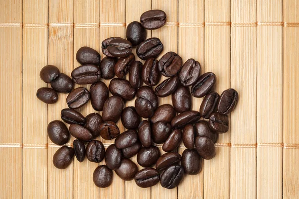 Scattered coffee grains on a bamboo napkin