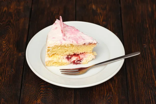 Rózsaszín torta szelet-a sötét fából készült háttér — Stock Fotó