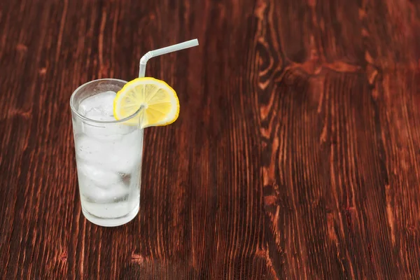 Glass of fresh lemonade with ice, cocktail on wooden background — Stock Photo, Image