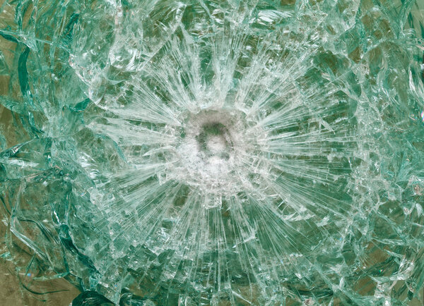 Bulletproof glass after the shooting with traces of bullets, test