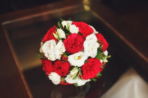 Весільний букет з червоних і білих троянд на столі — стокове фото