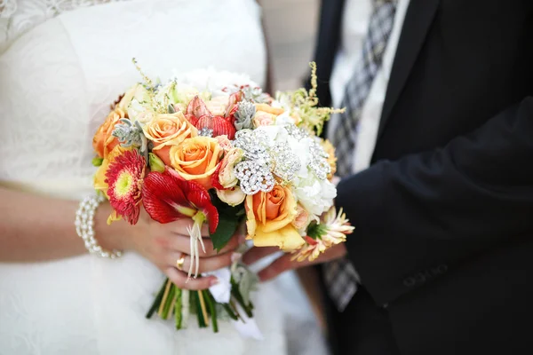 Novia y novio celebrando colorido ramo de bodas. Concepto de matrimonio — Foto de Stock