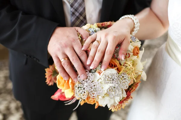 Mãos de noiva e noivo no buquê de casamento. Conceito de casamento — Fotografia de Stock