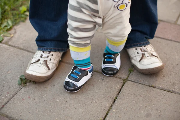 Pernas de pai e filho, dando os primeiros passos — Fotografia de Stock