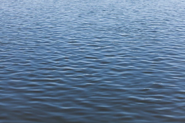 Wavy water surface of river with ripples, abstract background