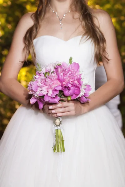 Bellissimo bouquet da sposa in peonia rosa nelle mani della sposa, primo piano — Foto Stock