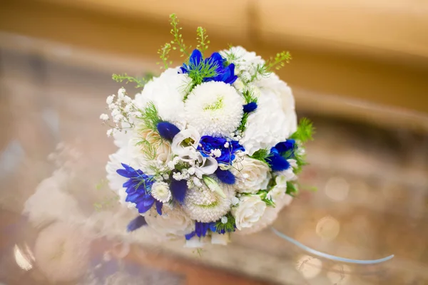 Buquê de casamento azul e branco de rosas na mesa de vidro — Fotografia de Stock