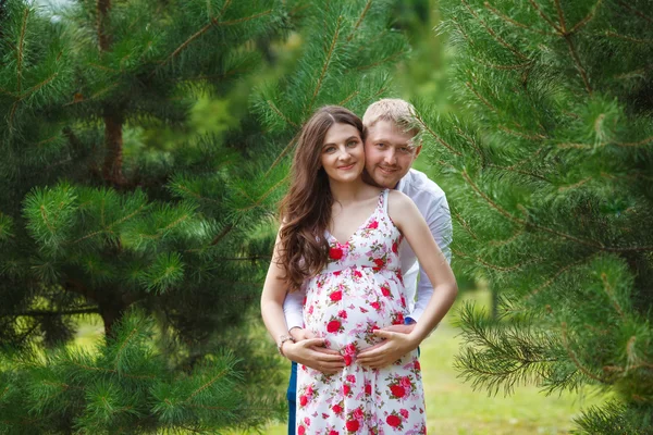 Donna incinta con marito che cammina nel parco — Foto Stock