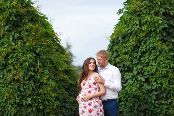 Mujer embarazada con marido caminando en el parque —  Fotos de Stock