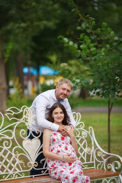 Mujer embarazada con marido sentada en el parque —  Fotos de Stock