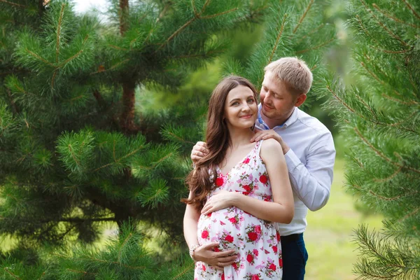 Donna incinta con marito che cammina nel parco — Foto Stock