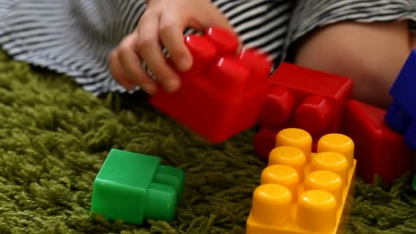 Petite fille mignonne jouant avec des blocs de jouets, gros plan — Video