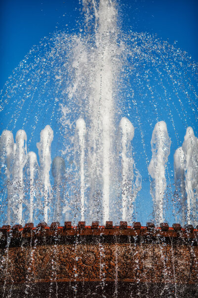 Many water fountain jets over blue sky, closeup