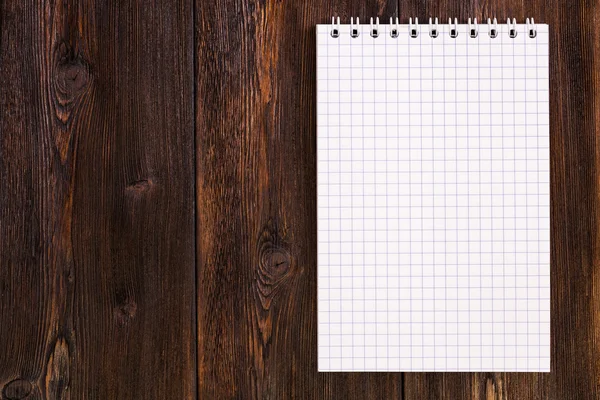 Caderno em branco em um fundo de madeira, espaço de cópia — Fotografia de Stock