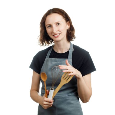 Beyaz arka planda mutfak aletleri olan önlüklü aşçı kadın.