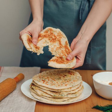 Khachapuri tutan kadının elleri, peynirle dolu Gürcü turtası.