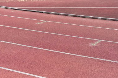 Bir stadyumdaki atletizm pistinin sığ saha derinliği, şerit detaylarını, dokusunu vurgulayan ve spor, spor, spor ve motivasyon temaları için mükemmel odaklanan yakın çekimi.