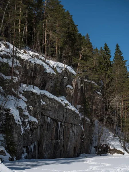 Finlandiya 'da kışın donmuş bir gölün kıyısında kaya oluşumları
