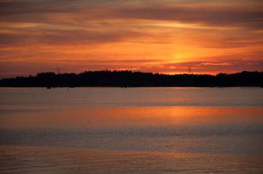 Gökyüzü, Finlandiya 'nın Pori kentindeki bir nehrin deltasındaki batan güneşle renklenmiştir.