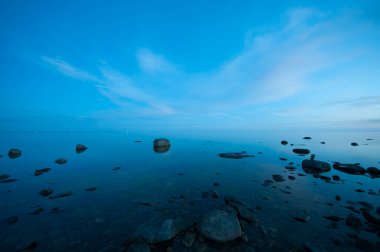 Finlandiya, Pori 'de gün batımından sonra mavi ışıkta Bothnian Denizi' nin kayalık kıyısı