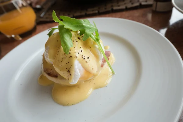 Αυγό hollandaise σάλτσα μπέικον ποσέ αυγά Benedict στο άσπρο πιάτο. — Φωτογραφία Αρχείου