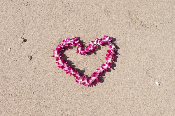 Collier guirlande fleur d'orchidée en forme de coeur amoureux sur la plage de sable blanc, voyage romantique de lune de miel de couple à Hawaï  . — Photo