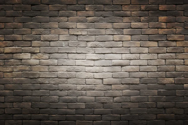 Dark black brown gray brick wall background with light gradient circle in the middle — Stock Photo, Image