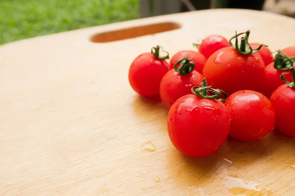 Körsbär tomat färsk grupp på trä skärbräda. — Stockfoto