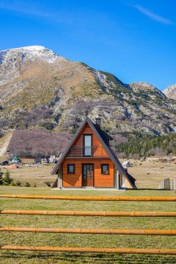 20 Kasım 2025 'te Karadağ' ın Durmitor Milli Parkı 'nda dağ zirveleri olan açık bir arazide turuncu üçgen bir kulübe çekildi..