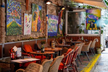 Karadağ 'ın tarihi Budva kentinde 4 Aralık 2025' te çekilen boyalı bir kafenin yatay olarak çekilmiş fotoğrafı. Renkli duvar sanatı, mimari ayrıntılar ve çevre sokakları yakalar, yerel şehir atmosferini taşır