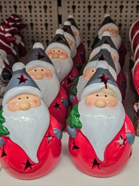 Rafta seramik Noel Baba heykelciklerinin yakın plan fotoğrafı. Şenlikli Noel dekoruna, koleksiyonluk tatil figürlerine ve mevsimlik mağaza vitrinlerine odaklan. Masa üstü dekorasyonu ve tatil temalı iç mekanlar için mükemmel.