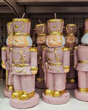 Dekoratif fındıkkıran biblo mumlarının pastel pembe tonlarda yakın plan fotoğrafı. Bayram dekorasyonuna, masa üstü dekorasyonlarına ve kolleksiyonlu Noel süslerine odaklan. Mevsimlik gösteriler ve rahat iç mekanlar için mükemmel.. 