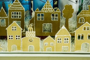 Mağaza vitrininde ayarlanmış Gotik tarzda minyatür Avrupa evlerinin görüntüsü. Detaylı mimari tasarım, tatil, dekorasyon veya kültürel içerik için mükemmel bir ortaçağ atmosferi yaratıyor..