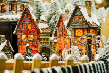 Minyatür Avrupa tarzı evlerin yatay yakın çekimleri, küçük ağaçlar ve yapay karlı bir Noel gösterisiyle düzenlenir. Mevsimlik dekorasyon, tatil içeriği ve koleksiyon sahneleri için ideal.