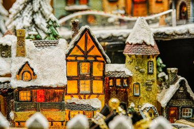 Küçük Noel ağaçları ve suni kar eşliğinde düzenlenmiş minyatür Avrupa tarzı evlerin yatay yakın çekimi. Tatil için mükemmel, mevsimlik ve koleksiyon içeriği.