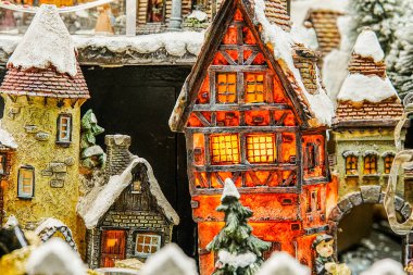 Küçük ağaçlı, yapay karlı ve masa üstünde tatil süsleri olan Avrupa tarzı minyatür Noel köyleri..