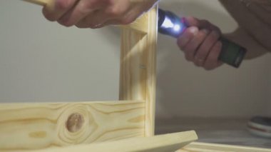 Metal anahtarla vida çeviren ve ahşap raf monte eden adam, Dolap.