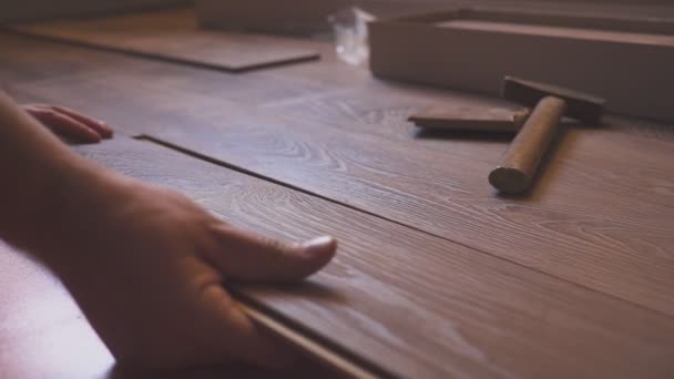 Working man installing laminate flooring in the house and connecting the laminate planks together. — Stock Footage Working man installing laminate flooring in the house and connecting the laminate planks together. Stock Footage