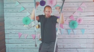 Neşeli bir iç mekanda elinde koltuk değnekleriyle dans eden mutlu bir adam.