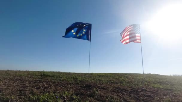 Drapeaux des États-Unis d'Amérique et de l'Union européenne agitant ensemble le vent. Véritable prise de vue en paysage. — Video
