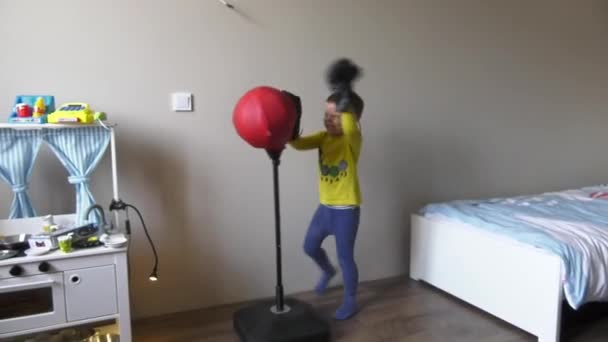 Niño boxeo en la habitación con juguete boxeo pera y guantes — Vídeo de stock