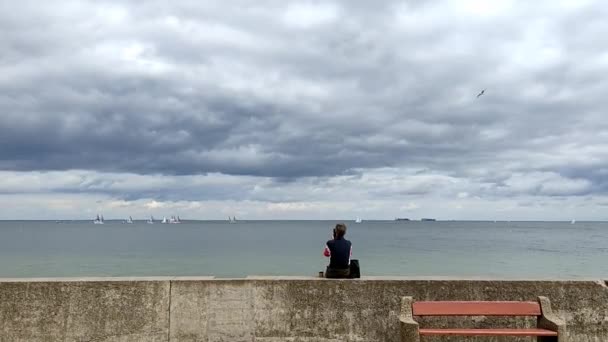 Meisje op de zeepromenade op een regenachtige dag — Stockvideo