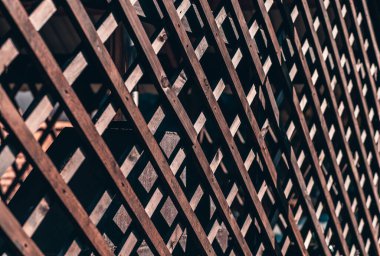 Ahşap çitin perspektif görüntüsü, güneşli bir günde, bir yazlık verandanın açık havasını sığ bir alan derinliği ve görüntünün ortasında seçici bir odak noktasıyla donatıyor.