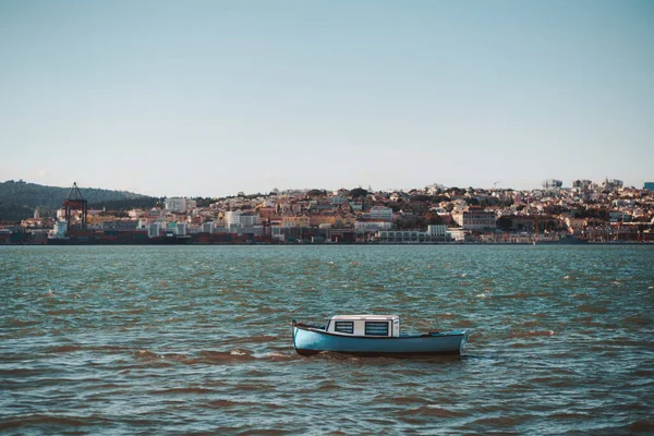 Kulübesinin içinde mavi çizgili perdeleri olan, Portekiz 'in Tagus nehrinin dalgalarında sallanan, küçük antik Lizbon evleriyle dolu bir nehir kıyısı olan,