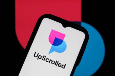 Bandung, Endonezya - 3 Şubat 2026: Bu fotoğraf ilüstrasyonlarında, UpScrolled uygulamasının logosu arka planda TikTok 'un görünür olduğu bir cep telefonunda sergilenmektedir.